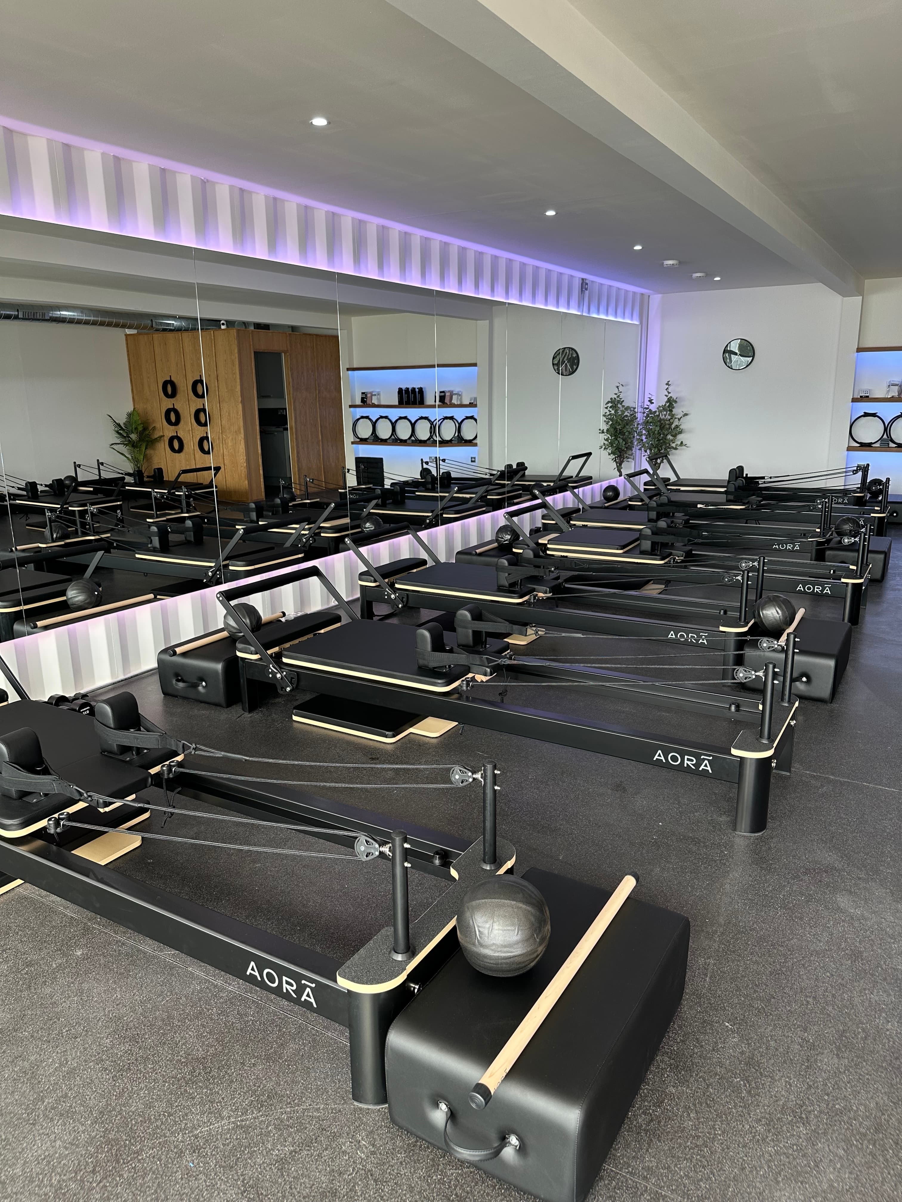 A client working through a reformer sequence at AORA Pilates